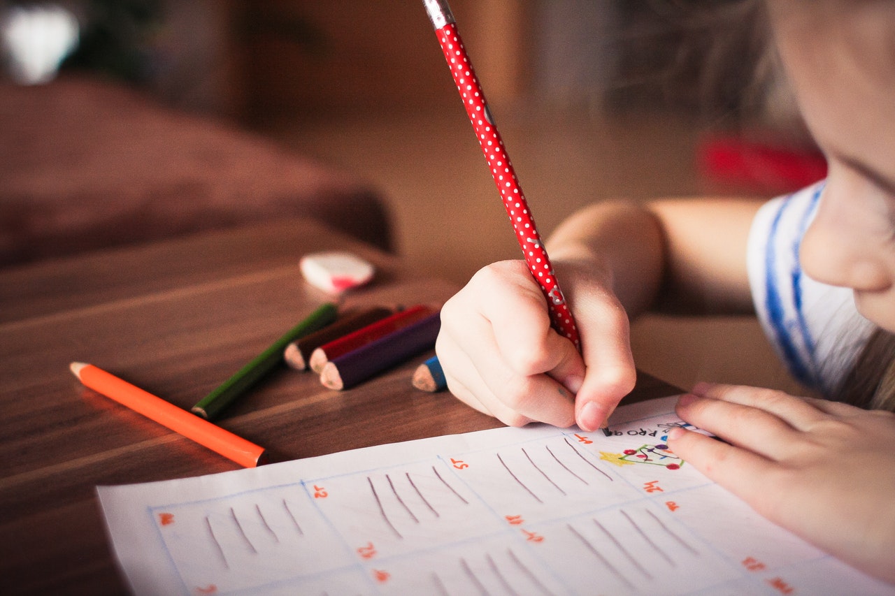 A child writing with a pencil.