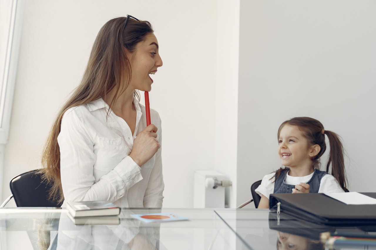 An adult supporting a child during an activity.